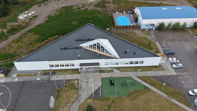 Loftmynd af Breiðdalsskóla þar sem sjá má endurnýjað þak og framkvæmdir við turn skólans.