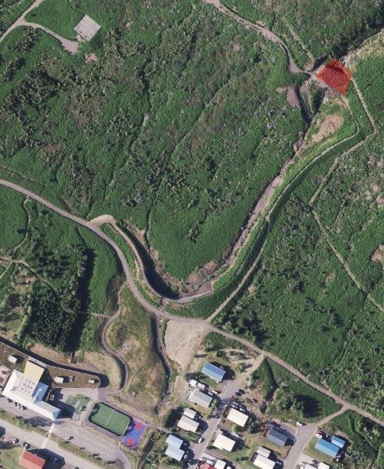 Loftmynd af hlíðinni ofan grunnskólans á Fáskrúðsfirði. Rauður reitur sýnir staðsetningu grjótstíflunnar í farvegi ofan byggðarinnar.